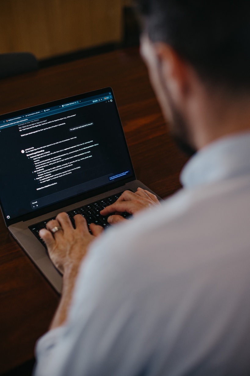 A professional working with an AI tool on a laptop